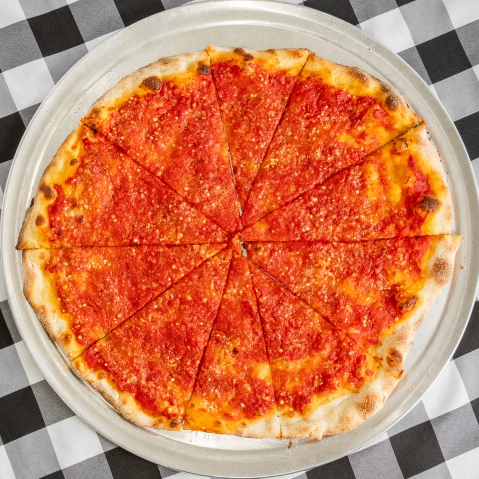 A sliced Cafe A Pizza plain tomato pie on a metal tray over a black and white checkered tablecloth.